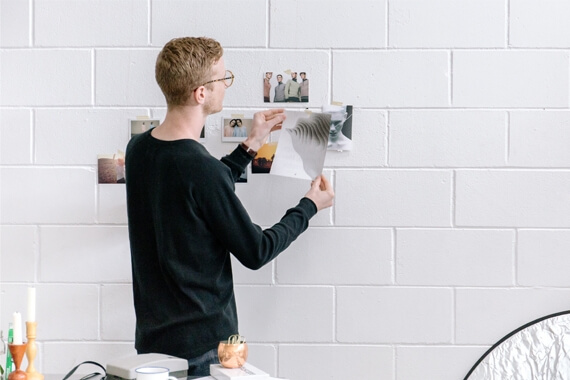 Man putting pictures on the wall